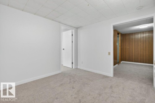 Spacious room featuring light-colored carpeting, white baseboards, and a white drop ceiling - 3E Twin Terrace, Edmonton, AB - Indoor Photo Showing Other Room