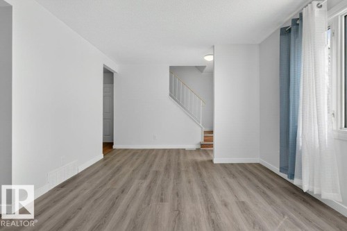 Open-concept room featuring wood-finish flooring, white baseboards, and a large window with natural light - 3E Twin Terrace, Edmonton, AB - Indoor Photo Showing Other Room