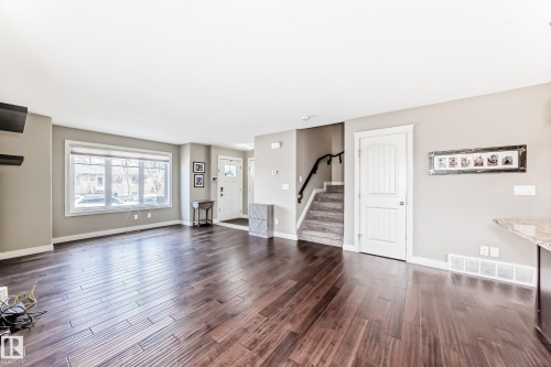 Spacious main living area featuring dark wood-finish flooring and neutral paint tones - 10519 114 Avenue, Edmonton, AB - Indoor Photo Showing Living Room