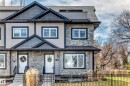 Two-story townhome exterior featuring stone and siding finishes, black trim windows, a shingled roof, a front yard with a black metal fence, and a concrete walkway - 10519 114 Avenue, Edmonton, AB  - Outdoor With Facade 