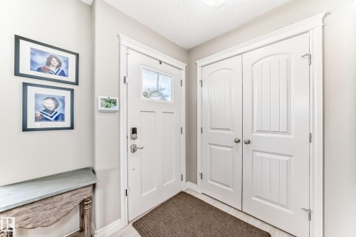 Entryway featuring a white paneled door with a clear glass insert, brushed nickel hardware, and a digital keyless entry system - 10519 114 Avenue, Edmonton, AB - Indoor Photo Showing Other Room