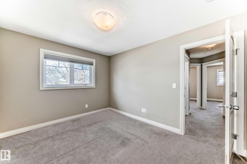 Carpeted room featuring a window with white trim, light taupe walls, and white baseboards - 10519 114 Avenue, Edmonton, AB - Indoor Photo Showing Other Room