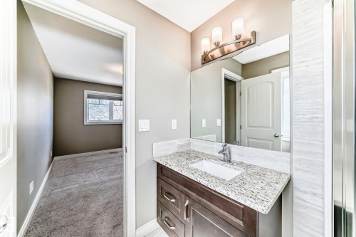 Bathroom vanity featuring a granite countertop, undermount sink, and dark wood cabinetry with chrome hardware - 10519 114 Avenue, Edmonton, AB - Indoor Photo Showing Bathroom