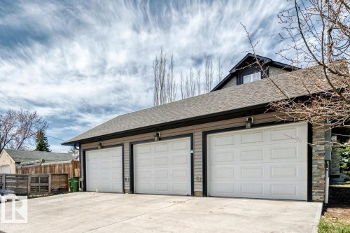 Three-car garage with white panel doors and exterior lighting fixtures - 10519 114 Avenue, Edmonton, AB - Outdoor With Exterior