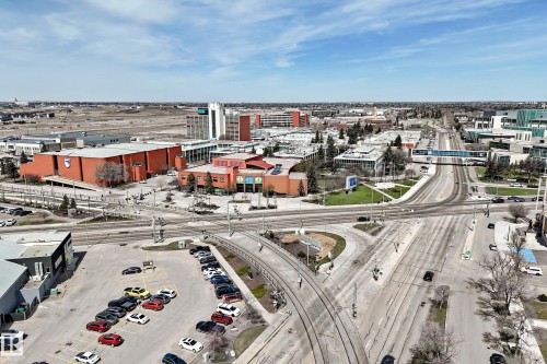 Urban aerial perspective showcasing a developed area with multiple commercial structures, an extensive road network, a light rail transit system, and surface parking areas - 10519 114 Avenue, Edmonton, AB - Outdoor With View