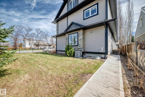 Exterior featuring light gray siding, dark trim, and stone accents - 10519 114 Avenue, Edmonton, AB - Outdoor