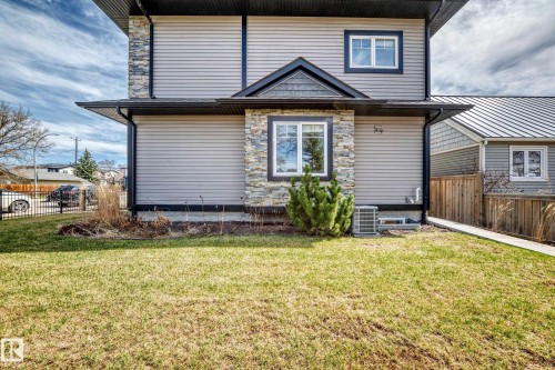 Exterior facade featuring light gray horizontal siding and stone accents - 10519 114 Avenue, Edmonton, AB - Outdoor With Exterior
