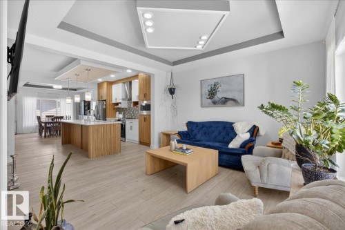 The open-concept living area features light-colored flooring, recessed lighting, and a kitchen with an island, light wood cabinetry, and stainless steel appliances - 1778 25A Street, Edmonton, AB - Indoor Photo Showing Living Room