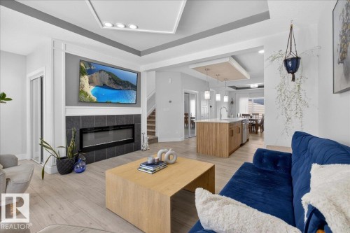 The living space features light-colored flooring, a modern fireplace with a dark tile surround, and a ceiling with recessed lighting - 1778 25A Street, Edmonton, AB - Indoor Photo Showing Living Room With Fireplace
