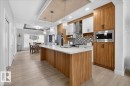 This kitchen features modern cabinetry with integrated stainless steel appliances, a spacious island with a white countertop, and contemporary pendant lighting - 1778 25A Street, Edmonton, AB  - Indoor Photo Showing Kitchen With Upgraded Kitchen 