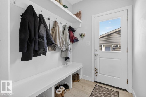 The property features an entryway with built-in storage, including a bench with open shelving, coat hooks, and an overhead shelf - 1778 25A Street, Edmonton, AB - Indoor Photo Showing Other Room