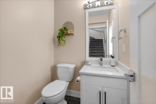 The property features a powder room with a white vanity, a rectangular sink, and a toilet - 1778 25A Street, Edmonton, AB - Indoor Photo Showing Bathroom