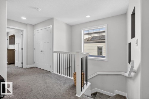 The upper landing features light gray walls, recessed lighting, and a window providing natural light - 1778 25A Street, Edmonton, AB - Indoor Photo Showing Other Room