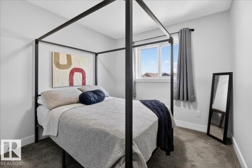This well-appointed room features light grey walls and dark grey carpeting, creating a neutral and calming atmosphere - 1778 25A Street, Edmonton, AB - Indoor Photo Showing Bedroom