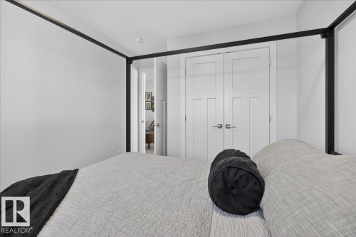 This room features a neutral color palette with white walls and a white paneled door - 1778 25A Street, Edmonton, AB - Indoor Photo Showing Bedroom
