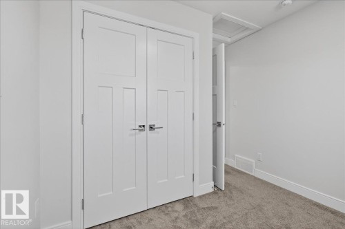 The interior features white walls, white doors with modern handles, and gray carpeting - 1778 25A Street, Edmonton, AB - Indoor Photo Showing Other Room