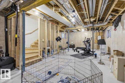 The property offers an expansive unfinished basement with exposed wooden beams and ductwork, providing a versatile space for future customization - 1778 25A Street, Edmonton, AB - Indoor Photo Showing Basement