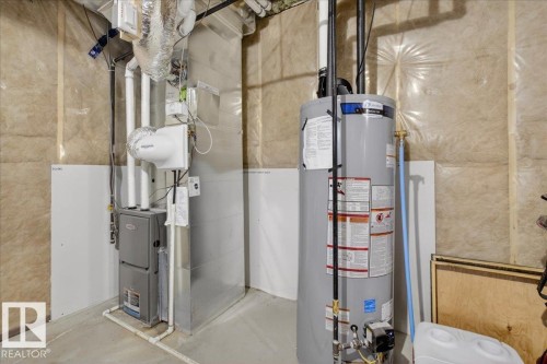 Utility area featuring a water heater, furnace, and exposed insulation - 1778 25A Street, Edmonton, AB - Indoor Photo Showing Basement