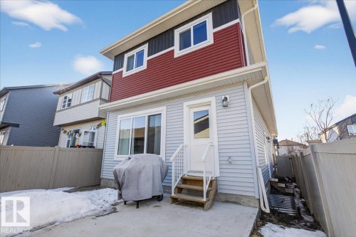 The property features light blue siding on the lower level and a combination of red and dark grey siding on the upper level - 1778 25A Street, Edmonton, AB - Outdoor With Exterior