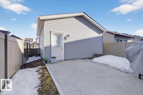 Detached garage with light-colored siding, a white door, and exterior lighting - 1778 25A Street, Edmonton, AB - Outdoor With Exterior