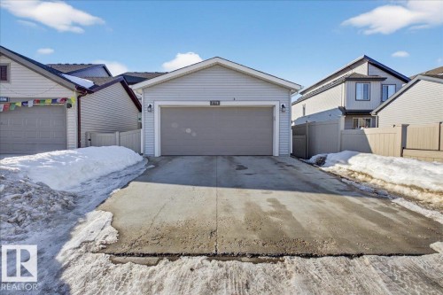 The property features an attached garage with a drive-through design and a concrete driveway - 1778 25A Street, Edmonton, AB - Outdoor