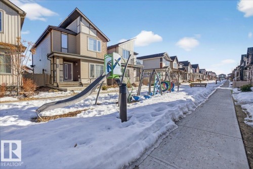 The property is situated in a neighbourhood featuring a playground with a slide and swing set - 1778 25A Street, Edmonton, AB - Outdoor