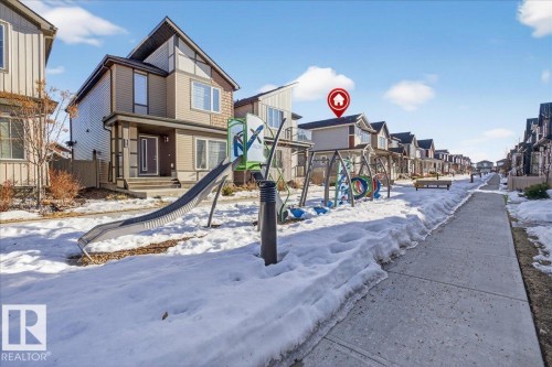 The property features a two-story exterior with light-colored siding and a covered front entryway - 1778 25A Street, Edmonton, AB - Outdoor