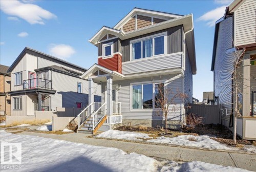 The property features a multi-level facade with horizontal siding, a covered porch, and white-framed windows - 1778 25A Street, Edmonton, AB - Outdoor