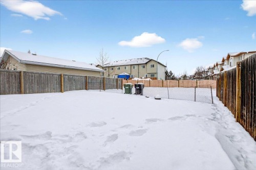 Yard layered in snow with a fenced backyard - 150 Acacia Circle, Leduc, AB - Outdoor
