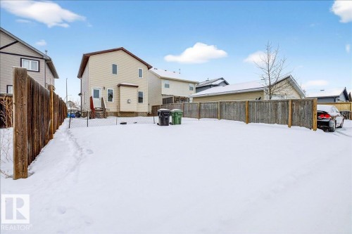 Snow covered rear of property featuring a fenced backyard - 150 Acacia Circle, Leduc, AB - Outdoor