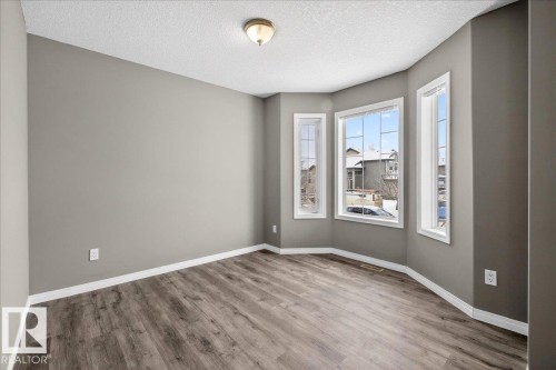 Empty room with wood finished floors and a textured ceiling - 150 Acacia Circle, Leduc, AB - Indoor Photo Showing Other Room