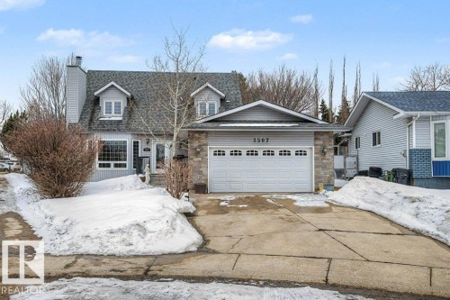 The property features a two-car garage with a white door and a paved driveway - Edmonton, AB - Outdoor With Facade