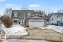 The property features a two-car garage with a white door and a paved driveway - Edmonton, AB  - Outdoor With Facade 
