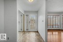 Entryway featuring a decorative glass front door, mirrored closet doors, and tile flooring - Edmonton, AB  - Indoor Photo Showing Other Room 