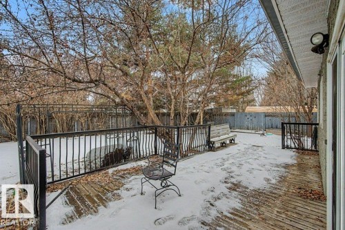 The property features a spacious deck with a black metal railing, offering direct access to the yard - Edmonton, AB - Outdoor