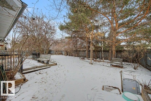 The property features a spacious yard with mature trees and a wooden fence - Edmonton, AB - Outdoor