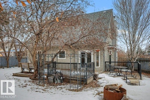 This property features a spacious backyard with a deck, mature trees, and a wooden fence - Edmonton, AB - Outdoor With Deck Patio Veranda