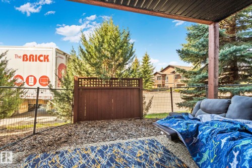 Covered patio featuring a slatted ceiling, wood support beams, and a decorative privacy fence - 2201 Graybriar Green, Stony Plain, AB - Outdoor With Deck Patio Veranda