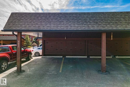 Covered parking structure with asphalt shingle roofing, dark brown support beams, and individual storage units - 2201 Graybriar Green, Stony Plain, AB -  Photo Showing Garage