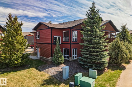 Two-story residence featuring red horizontal siding with dark trim accents and a dark shingle roof - 2201 Graybriar Green, Stony Plain, AB - Outdoor