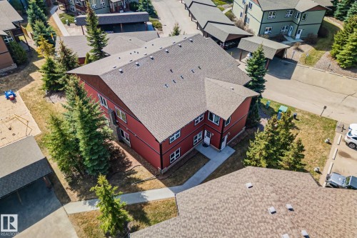 Red multi-story building featuring a gray shingled roof and multiple white-trimmed windows - 2201 Graybriar Green, Stony Plain, AB - Outdoor With Deck Patio Veranda