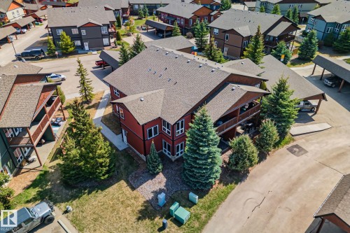 Contemporary condominium building featuring a rich red siding and multiple balconies - 2201 Graybriar Green, Stony Plain, AB - Outdoor