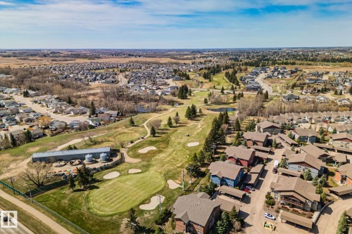 Aerial perspective showcasing a residential area with a golf course, expansive green spaces, and dense tree coverage - 2201 Graybriar Green, Stony Plain, AB - Outdoor With View