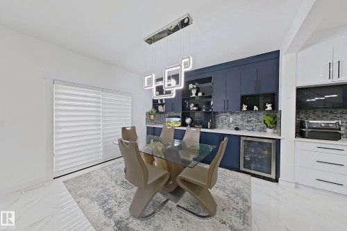Integrated dining area featuring a modern geometric chandelier over a glass-top table - 1210 Peregrine Terrace, Edmonton, AB - Indoor
