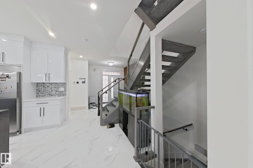 Modern open-tread staircase with glass panel railing and gray metal balusters - 1210 Peregrine Terrace, Edmonton, AB - Indoor Photo Showing Other Room