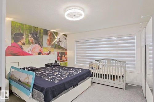 Bedroom featuring light gray carpet, a ceiling-mounted light fixture, and a window with horizontal blinds - 1210 Peregrine Terrace, Edmonton, AB - Indoor Photo Showing Bedroom