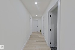 Bright hallway featuring wood-finish flooring and recessed ceiling lighting - 