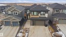 Contemporary two-story residence featuring a two-car garage with modern frosted glass panels and stone accents - 1210 Peregrine Terrace, Edmonton, AB  - Outdoor With Facade 