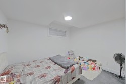 White walls featuring a single horizontal window with horizontal blinds and a recessed ceiling light - 