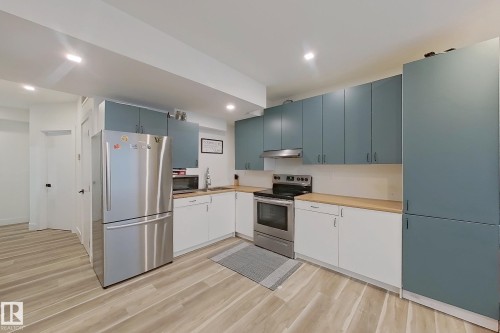 Modern kitchen featuring two-tone cabinetry with wood-finish countertops - 1210 Peregrine Terrace, Edmonton, AB - Indoor Photo Showing Kitchen With Stainless Steel Kitchen